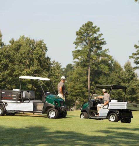New Utility Car being used on golf green with golfers nearby.